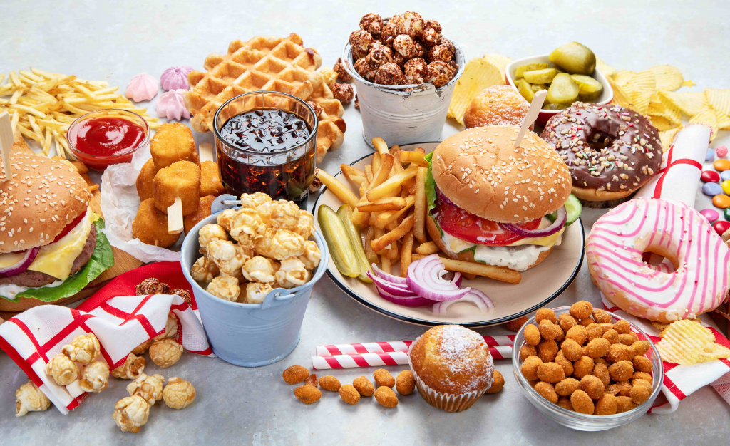 various-american-food-french-fries-hamburgers-nuggets-hotdog-chips-popcorn-sauces-white-background-top-view (1).jpg